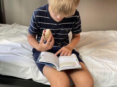 Eating a peanut butter sandwich and reading the guidebook in the hostel.